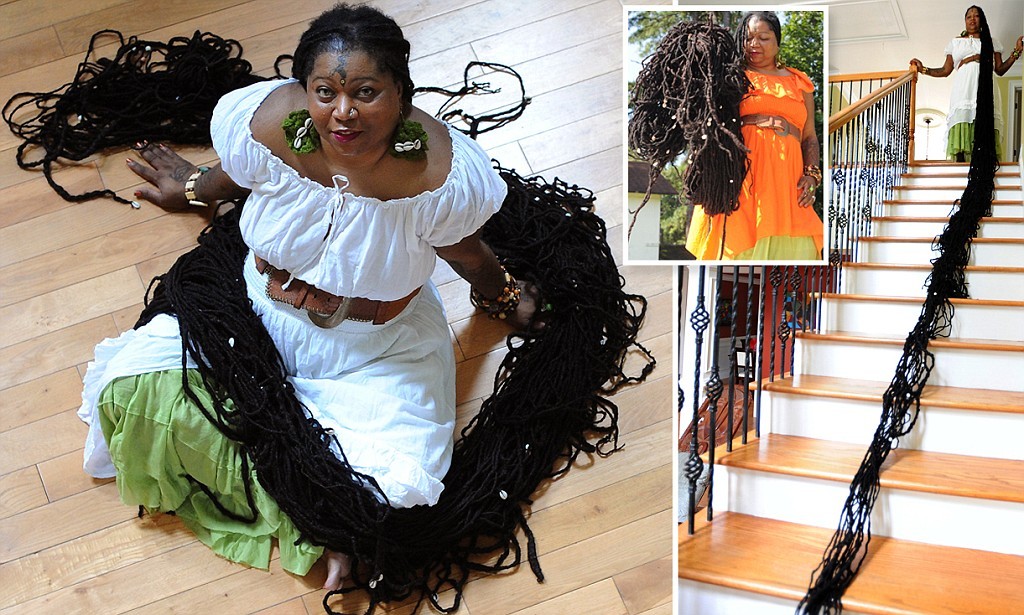 ***EXCLUSIVE - NO ONLINE USAGE UNTIL 00:01 MONDAY 19 AUGUST***  JONESBORO, GA - UNDATED: Asha Mandela shows her record breaking dreadlocks while sitting on the floor of her home in Jonesboro, Georgia. Asha Mandela holds the world record for the longest all-natural dreadlocks.  MEET hair fanatic Asha Mandela - whose 55ft locks are longer than a London BUS. But despite owning a world record, the 47-year-old wants to go BIGGER - even though doctors warn she could PARALYSE herself. Asha refuses to cut 'her baby' though - saying it has helped her overcome cancer, two strokes and two heart-attacks. Her hair weighs almost three stone - the weight of a reception-age child - and takes two days to wash and dry. She also worries that someone with a 'hair fetish' will cut a chunk off when she is not looking. However, there is one area it has not affected - her love life - and three-times married Asha even claims it adds 'a bit of spice'. Guinness gave Asha the title of world's longest dreadlocks in 2009 when they were 22ft long. But a new unofficial measurement this week (Aug 10) puts one particular lock of hair at 55ft 7ins.  PHOTOGRAPH BY Jason Braverman / Barcroft Media  UK Office, London. T +44 845 370 2233 W www.barcroftmedia.com  USA Office, New York City. T +1 212 796 2458 W www.barcroftusa.com  Indian Office, Delhi. T +91 11 4053 2429 W www.barcroftindia.com