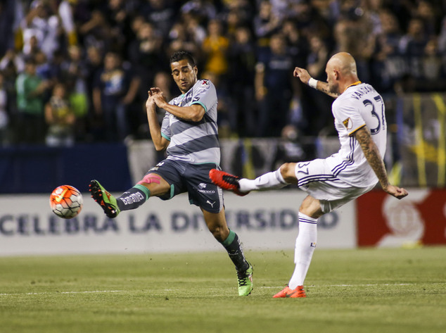 Los Angeles Galaxy defender Jelle Van Damme, right, shoots the ball against Santos Laguna midfielder Diego Gonzalez during the first half of a CONCACAF Champions League soccer quarterfinal in Carson, Calif., Wednesday, Feb. 24, 2016. (AP Photo/Ringo H.W. Chiu)